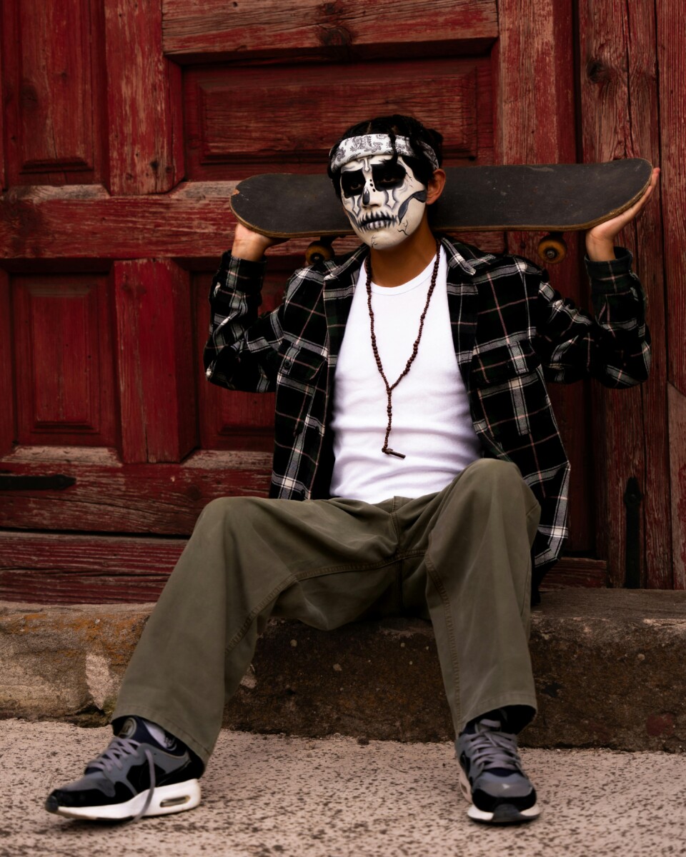 Man with Face Paint Posing with a Skate Board